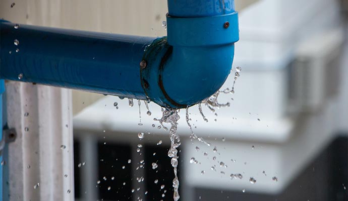 closeup view of leaked and splash water from the blue pipe